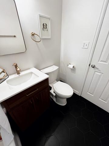 Bathroom vanity and black hex tile floor